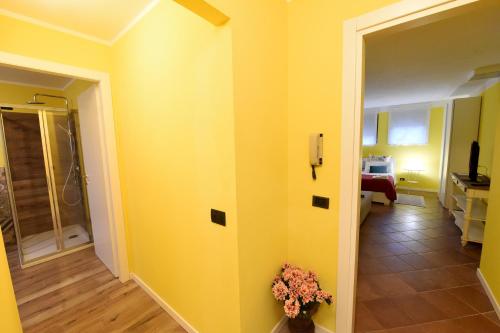 a hallway with a yellow wall and a room with a bathroom at Villa Campo dei Fiori in Casciago