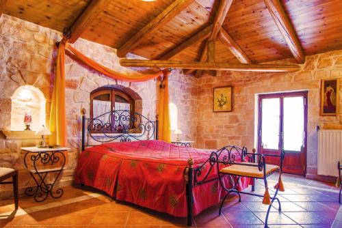 a bedroom with a large bed in a stone room at The Vivian - Luxury Stone Villa in Koiliomenos