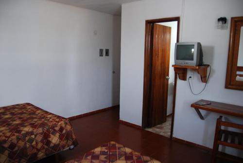 Habitación con cama y TV en la pared. en Hotel Alux Cancun en Cancún