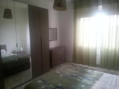 Schlafzimmer mit einem Bett, einer Kommode und einem Spiegel in der Unterkunft Vittoria_Albissola in Albissola Marina