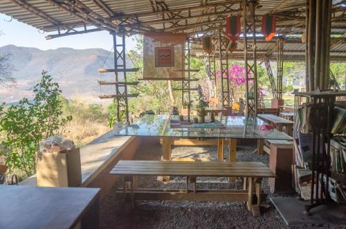 a room with a table and a bench and a view at Avanti Kalagram Hill Top Resort, Mulshi in Kolvan