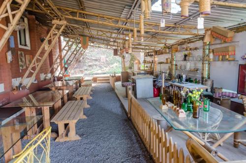 a restaurant with tables and benches in a room at Avanti Kalagram Hill Top Resort, Mulshi in Kolvan