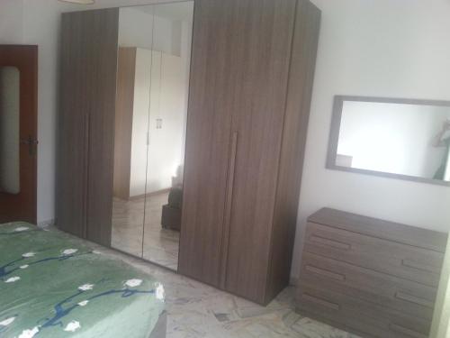 ein Schlafzimmer mit einem Schrank, einer Kommode und einem Spiegel in der Unterkunft Vittoria_Albissola in Albissola Marina