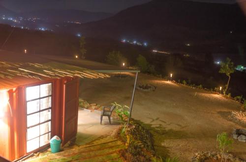 a house with a window and a chair at night at Avanti Kalagram Hill Top Resort, Mulshi in Kolvan