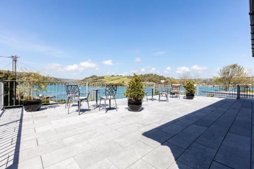 a patio with chairs and a table with a view of the water at Shearwater Country House Accommodation in Union Hall