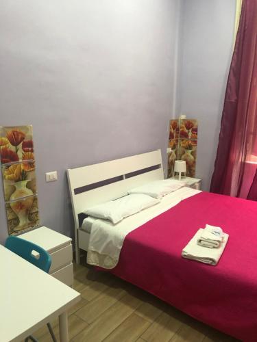 una camera da letto con un grande letto con una coperta rosa di La Casa Di Fafa a Napoli