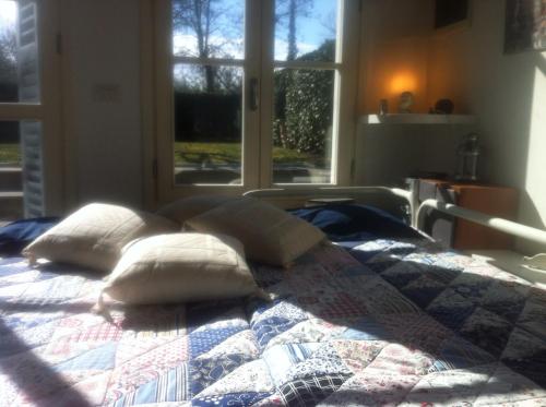 1 cama con almohadas en una habitación con ventana en Firenze in collina con piscina en Bagno a Ripoli