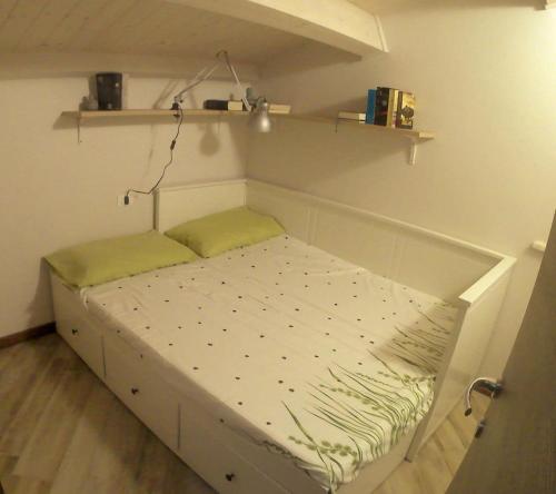 a small bed in a room with a shelf at Appartamento in centro storico in Ortona