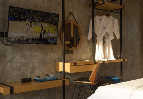 a bedroom with a dressing room with a suit and a mirror at Wheeler Bed &Bike in Bangsaen