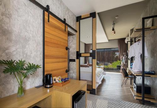 a living room with a wooden pivot door in a house at Wheeler Bed &Bike in Bangsaen