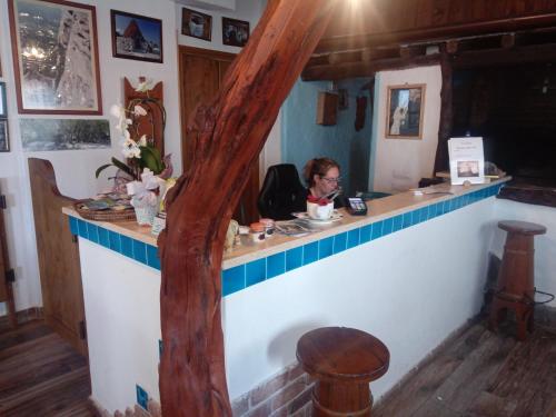 a woman sitting at a bar in a restaurant at Agriturismo Codula Fuili in Cala Gonone