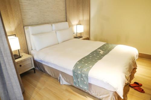 a bed in a room with two lamps and a bed sidx sidx sidx at Sea Passion Hotel in Koror