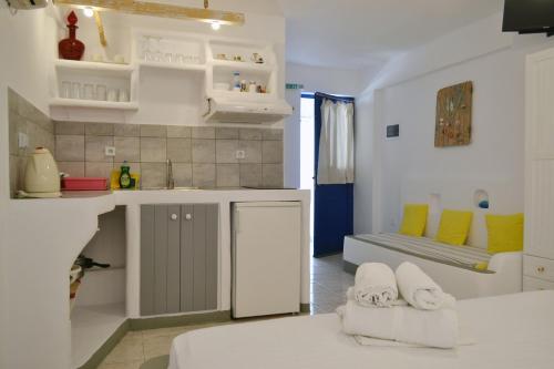 a white kitchen with a couch and a table at Paleochori Studios in Paliochori