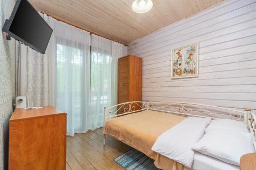 a bedroom with a bed and a flat screen tv at Bird Valley in Sinyak