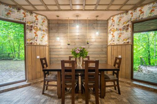 a dining room with a wooden table and chairs at Bird Valley in Sinyak