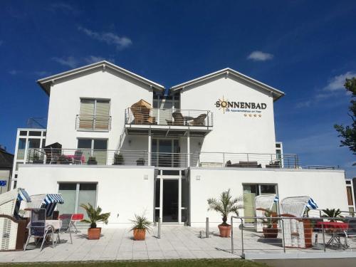 een wit gebouw met stoelen ervoor bij Appartement Nr_ 12 im Sonnenbad in Sassnitz