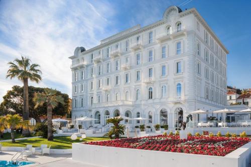 a large white building with a large clock on it at Miramare The Palace Resort in Sanremo