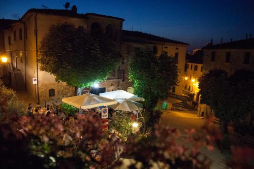 a street with tables and umbrellas at night at Le Vecchie Cantine in Chianni