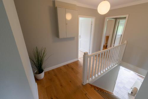 a staircase in a house with a potted plant at Lehrerwohnung in Tümlauer Koog
