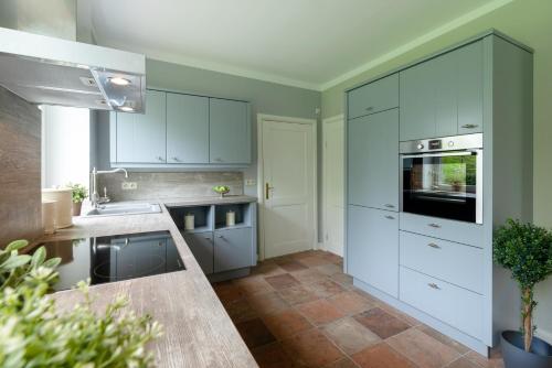 a kitchen with white cabinets and a counter top at Lehrerwohnung in Tümlauer Koog