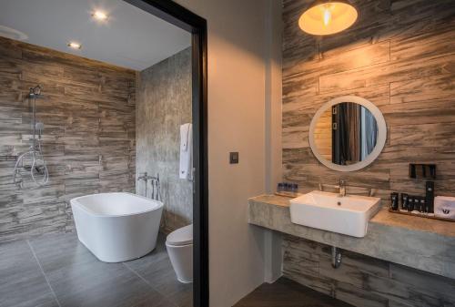 a bathroom with a white sink and a mirror at Wheeler Bed &Bike in Bangsaen
