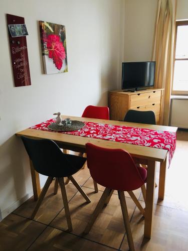 a dining room table with four chairs around it at Claes Weinquartier - Appartements & Wein by Niko Schmitt in Trittenheim