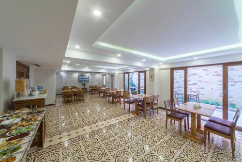 a dining room with tables and chairs and windows at Lalinn Hotel in Istanbul