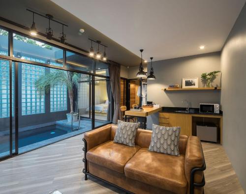 a living room with a couch and a kitchen at Wheeler Bed &Bike in Bangsaen