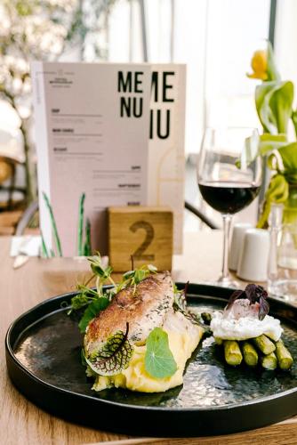 a plate of food on a table with a glass of wine at poznańska19 in Nowy Tomyśl