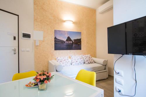 a living room with a white couch and a tv at La Dotta Apartments in Bologna
