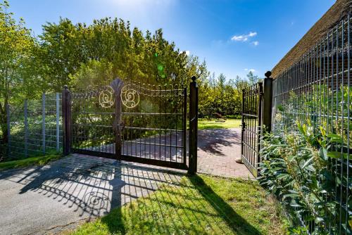 a gate to a garden with a fence at Lehrerwohnung in Tümlauer Koog