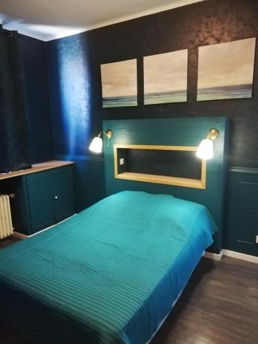 a blue bedroom with a bed with two lights on it at Gîte, le Colmar Vintage Station in Colmar