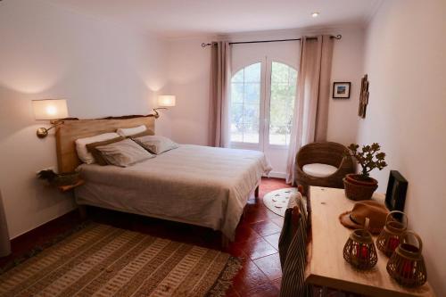 ファレリエスにあるLa Casa Menorcaのベッドルーム1室(ベッド1台、窓、テーブル付)