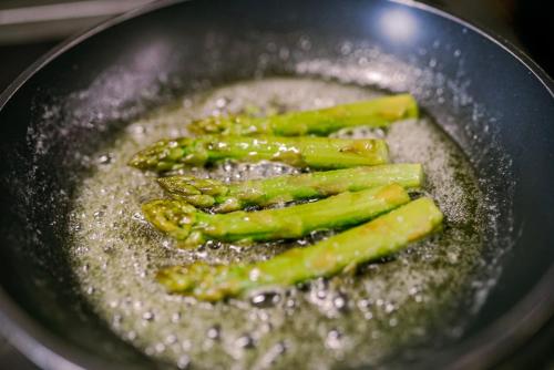 three spears of green vegetables cooking in a pan at poznańska19 in Nowy Tomyśl