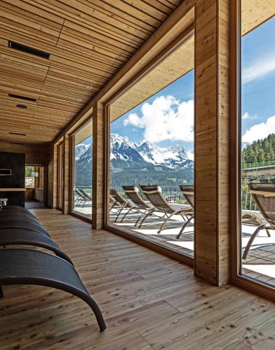 a room with a view of mountains through windows at Tirol Lodge in Ellmau