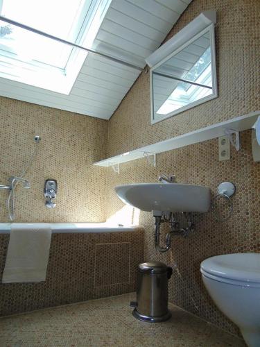 a bathroom with a sink and a toilet and a window at Landhaus Kogel in Ofterschwang