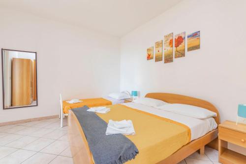 1 dormitorio con 2 camas y espejo en Residence Villammare, en Villammare