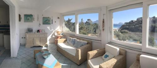 a living room with two couches and two windows at VILLA ARANZOS in Golfo Aranci