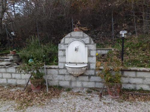 a toilet in a stone wall with two potted plants at Casetta dei "Prati" in Vaglio di Basilicata