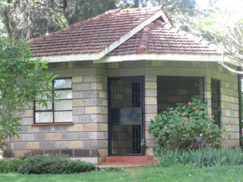 a small brick house with a door and a window at ACK St.Julians Centre in Limuru