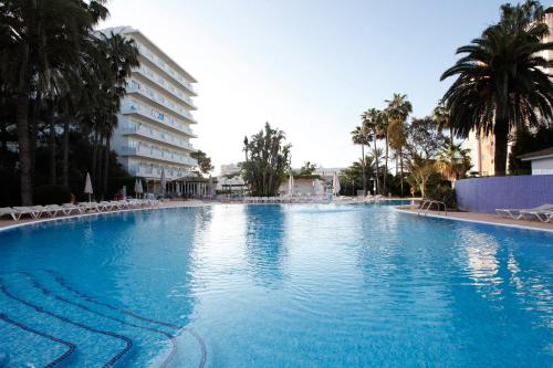 uma grande piscina com cadeiras e um edifício em Oleander em Playa de Palma