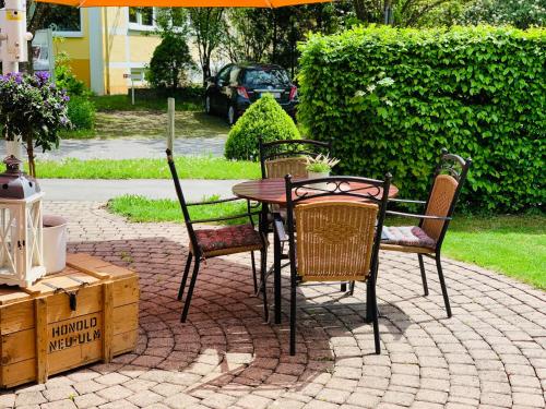 a table with chairs and an umbrella on a patio at Parkhotel in Bad Waldsee