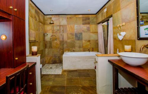 a bathroom with a tub and a sink and a bath tub at Ladera - Vista Self-catering Guesthouse in Paarl