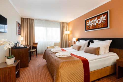 a hotel room with two beds and two lamps at Avalon Hotel & Conferences in Riga