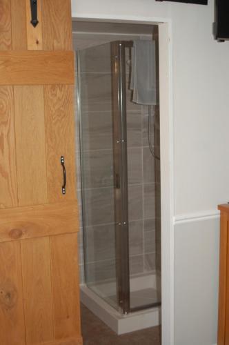 a shower with a glass door in a bathroom at Knights Rest in Shanklin