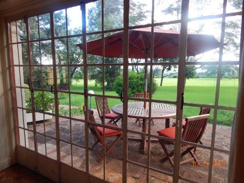 a patio with a table and chairs and an umbrella at ACK St.Julians Centre in Limuru