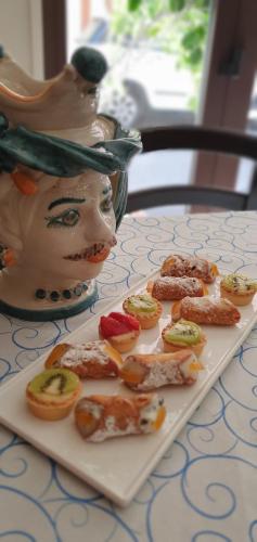 a plate of food on a table with a statue at Ines bed and breakfast in Giardini Naxos