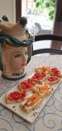 a plate of food on a table next to a vase at Ines bed and breakfast in Giardini Naxos