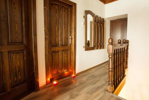 a hallway with a wooden door and a staircase with red candles at Guest House Panorama in Gela