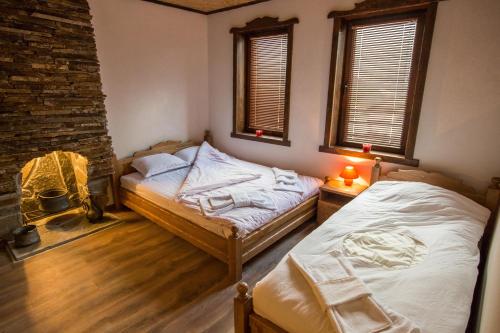 two twin beds in a room with two windows at Guest House Panorama in Gela